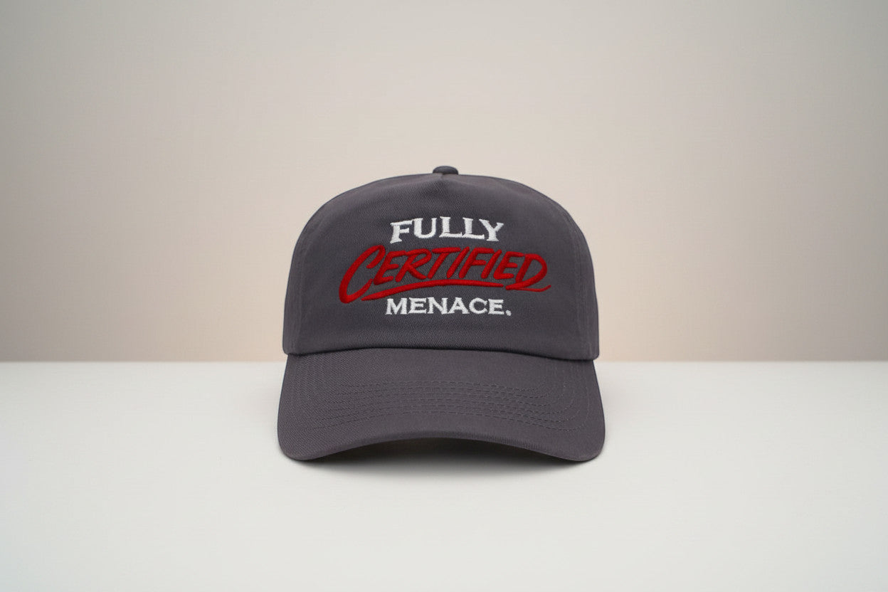 The Cap Shack charcoal grey 5-panel cotton cap with embroidered "FULLY CERTIFIED MENACE." in red and white. Pre-curved peak.